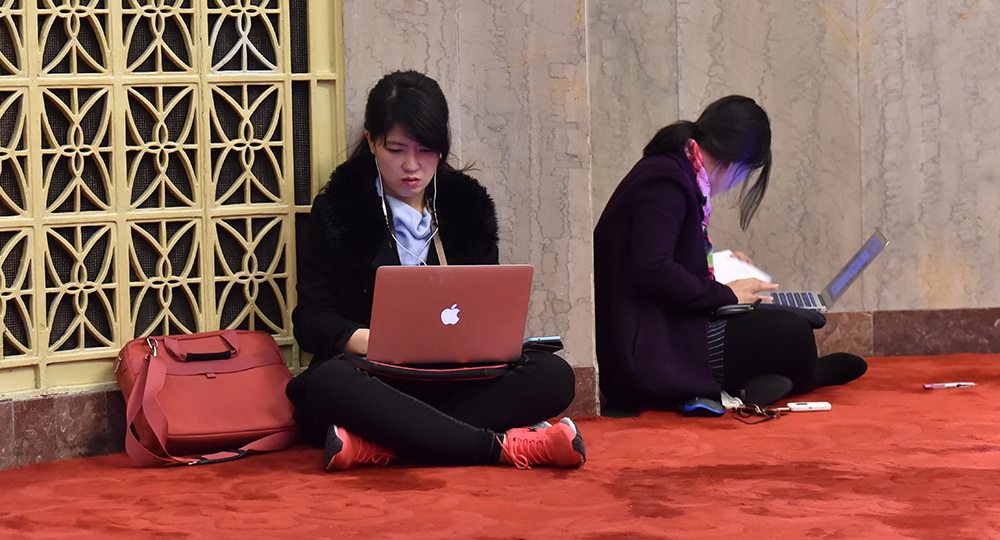巾帼不让须眉 致敬两会上的女记者   3月4日，女记者席地而坐争分夺秒编发稿件。