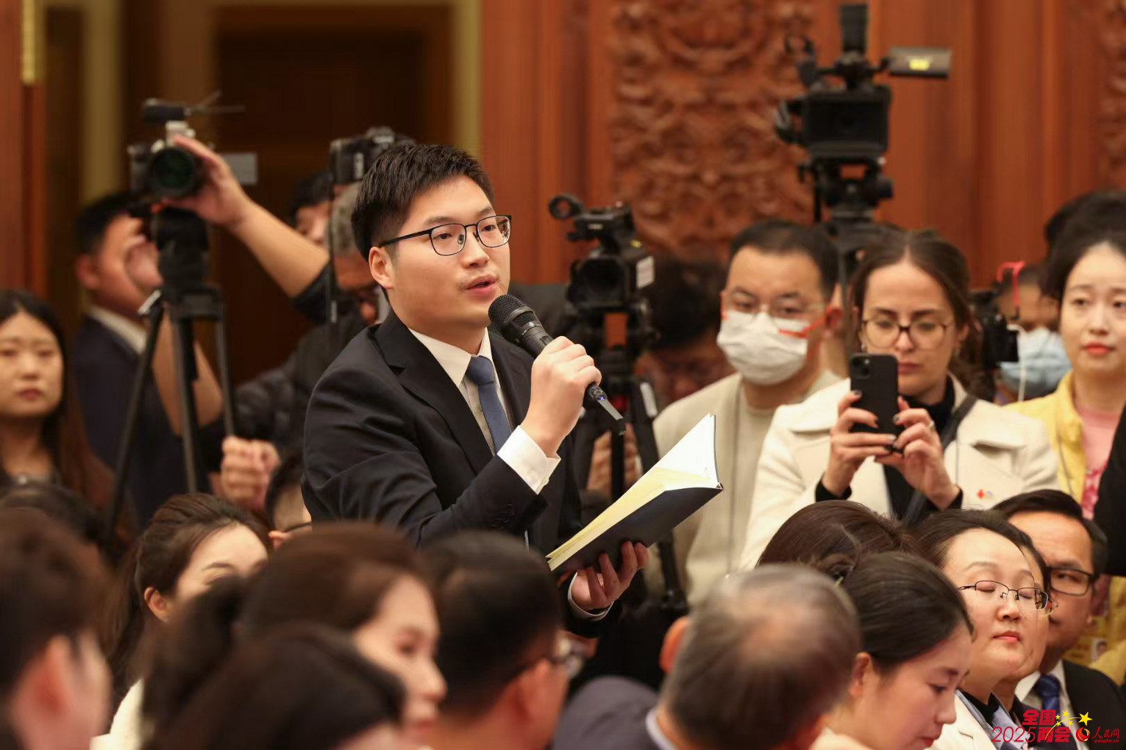人民日報記者在全國政協十四屆三次會議新聞發布會現場提問。人民網記者 李兆民攝