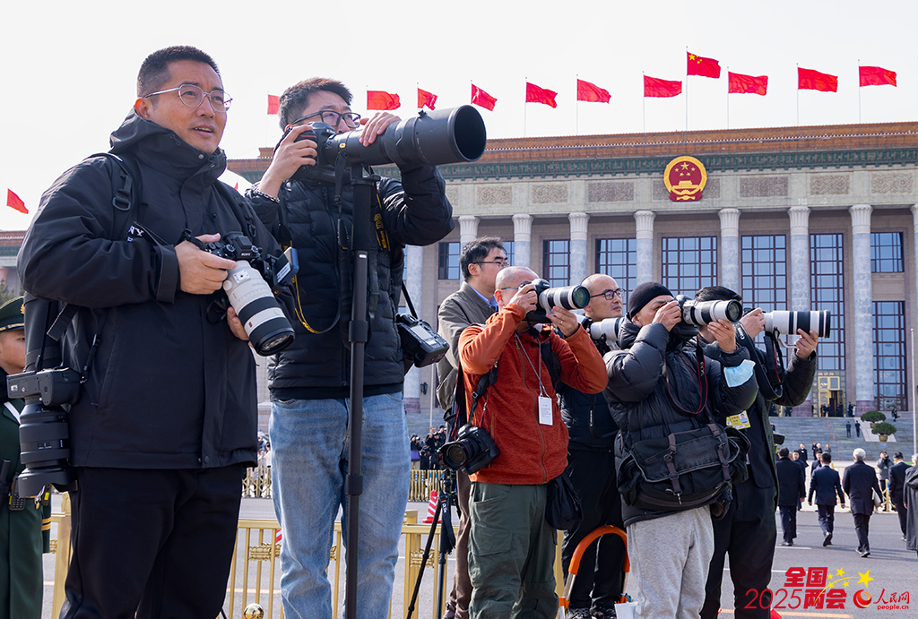 会场外，记者们早早架起“长枪短炮”，捕捉政协委员步入会场的瞬间。人民网记者 李兆民摄