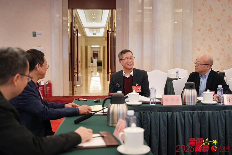 特邀界别小组会议结束后，多名委员继续就AI话题进行讨论。人民网记者 苗子健摄
