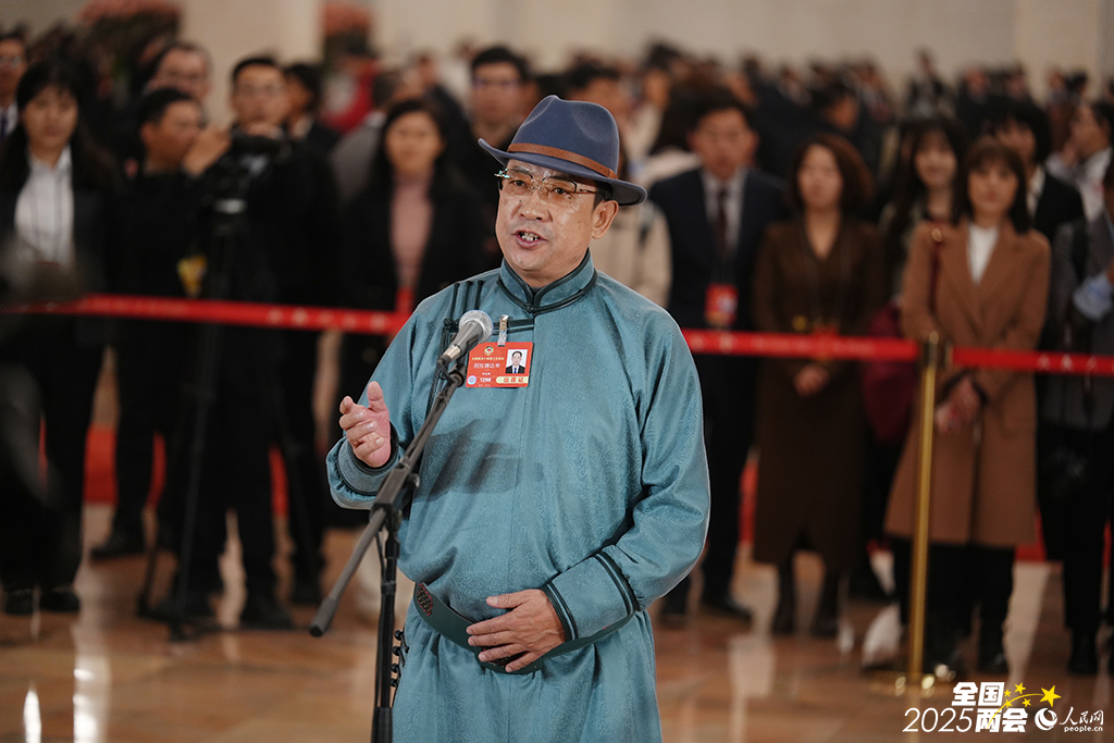 全国政协委员阿拉腾达来接受媒体采访。