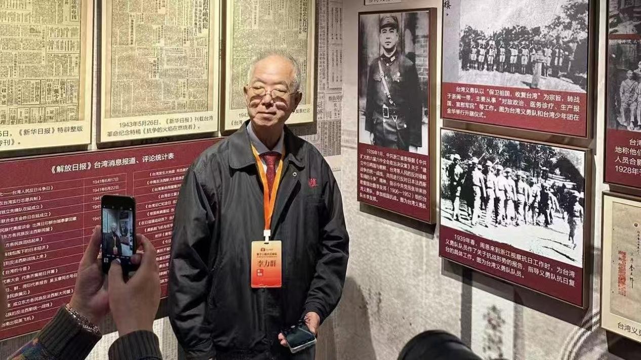 2025年10月,台湾抗日名将李友邦之子李力群参观“共铸民族魂——台盟中央纪念中国人民抗日战争暨世界反法西斯战争胜利80周年、台湾光复80周年特展”,在其父亲领导的台湾抗日义勇队照片前合影。