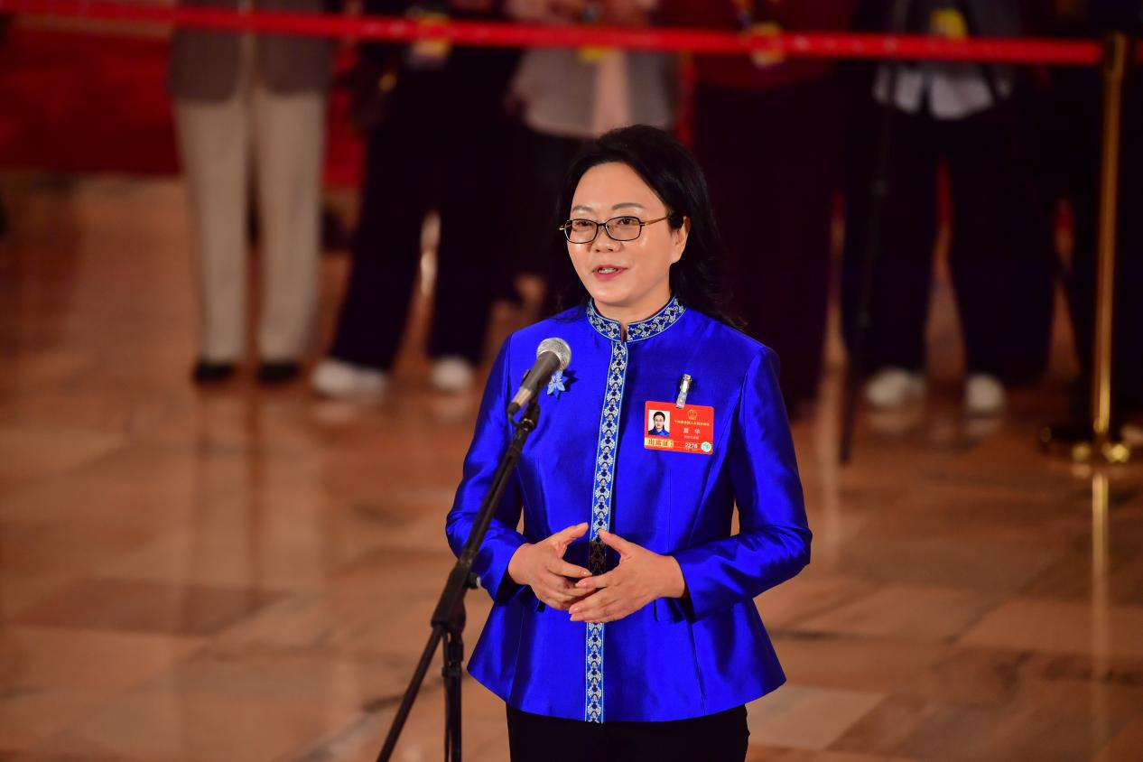 3月12日，贵州省级非物质文化遗产传承人、依文集团董事长夏华代表在“代表通道”上回答记者提问。人民网 时雨摄