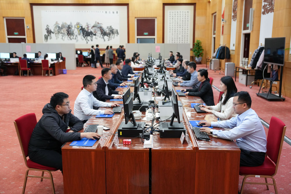2025年3月9日，十四屆全國人大三次會議秘書處工作人員在認真工作。新華社記者 鄭煥鬆 攝