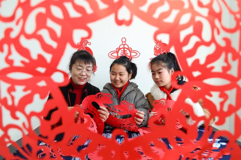 △2025年2月13日，在河北唐山一所小學舉行的“非遺進校園”開學第一課主題活動中，剪紙藝人向學生傳授剪紙技藝。
